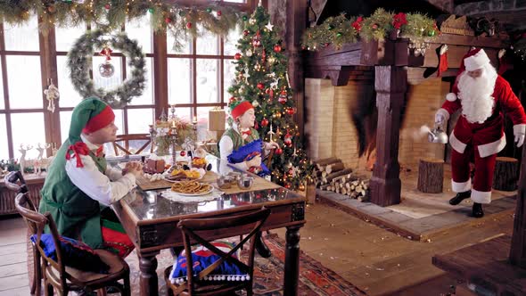 Elves sitting at the table on beautifully decorated background for Christmas.