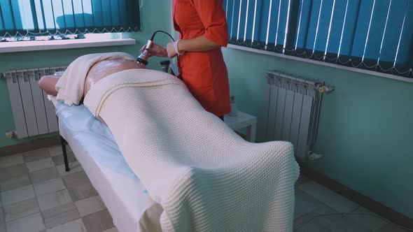 Cosmetologist Does Vibromassage To Plussize Woman in Clinic