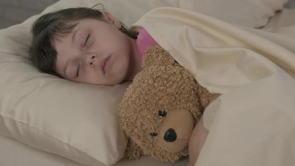 The Kid Sleeps with a Teddy Bear.