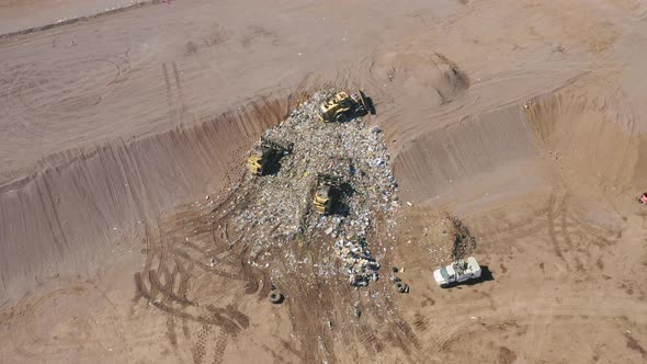 A Landfill Compactor Group of Workers Burying the Garbage in the Ground