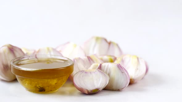 Red Inion Oil in a Container on Table on White Background