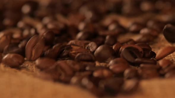 Falling Brown Coffee Beans on Sacking, Close Up