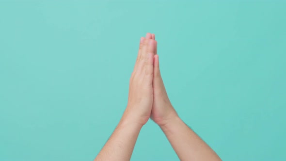 Close up shot of male hand raising with hand clapping gesture in isolate blue screen in background