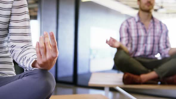 Business people performing yoga on table