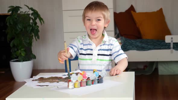 Little Boy Draws Picture On Paper