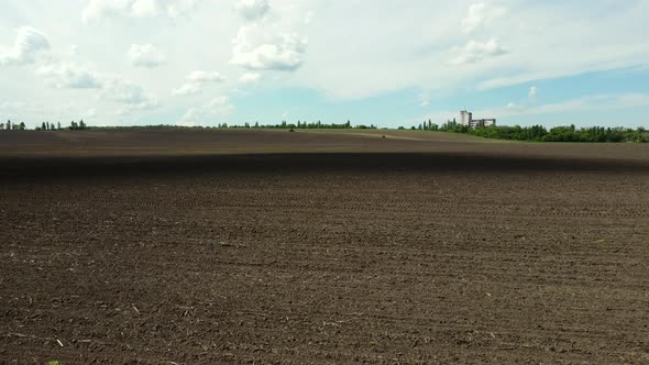 Aerial Drone View Flight Over Huge Plowed Field and Blue Sky