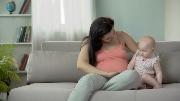 Pregnant Woman Touching Belly Tenderly, Playing With Sweet Little Baby Girl