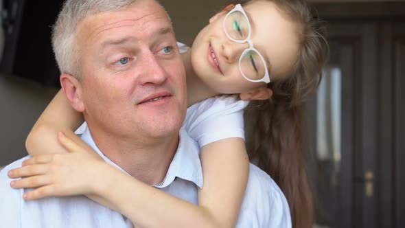 Family Portrait of Mature Father and Little Blonde Daughter Hugging at Home While Celebrating Father