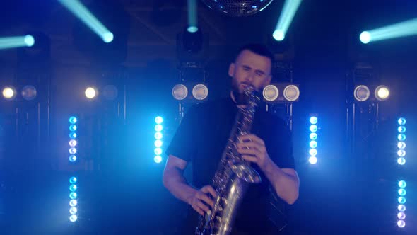 Live Performance of Saxophonist Man with Saxophone Dancing on Concert Musician Stage with Lights