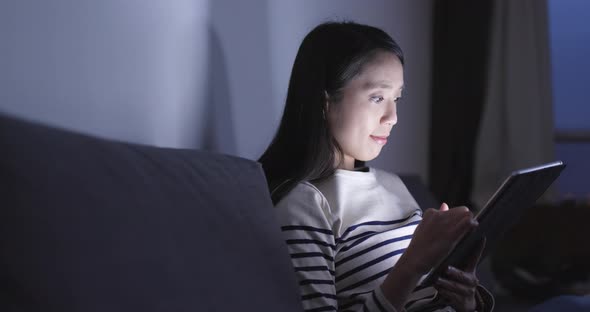 Woman Looking at Tablet Computer at Home