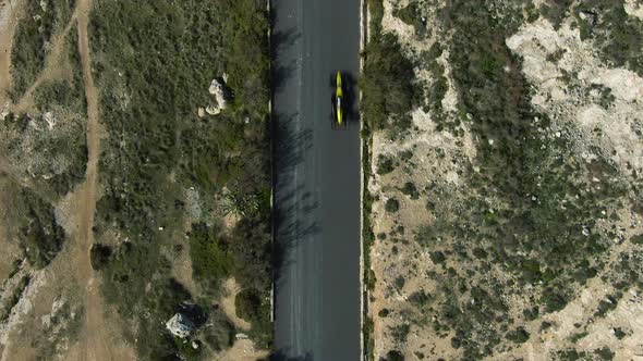 Race Car Driving On The Road Track Heading Towards The U-turn Direction On A Bright Weather - Aerial