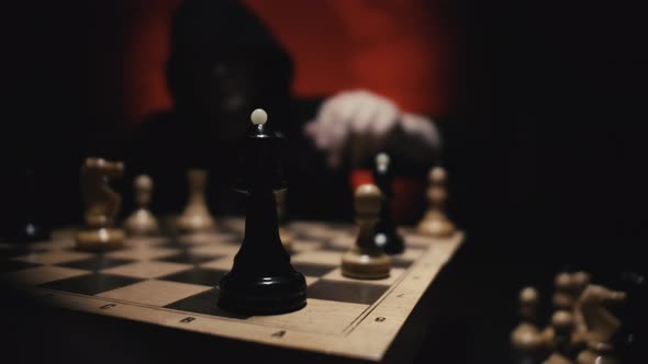 Man in Hoodie Moving White Queen Defeating White King of Opponent During Chess Game