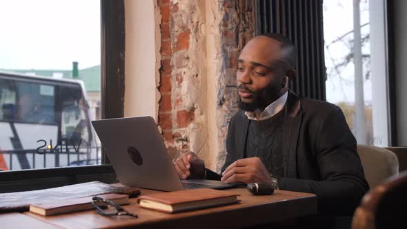 a Young Aspiring AfricanAmerican Investor Works at a Computer Analyzes the Securities Market