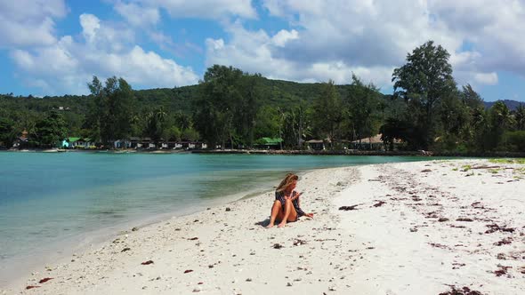 Beautiful beauty models travelling spending quality time at the beach on clean white sand and blue b