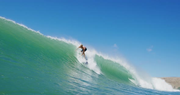 Surfer riding epic ocean wave getting barreled