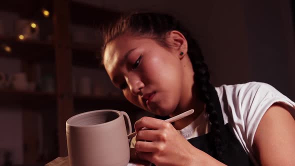 Pottery in the Studio Woman Holding a Cup on the Plate and Smearing Parts of Clay on the Joint on