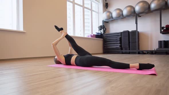 4x Slow Motion Video of Beautiful Young Woman Working Out and Stretching Indoors