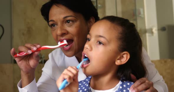 Grandmother and granddaughter brushing together in bathroom 4k