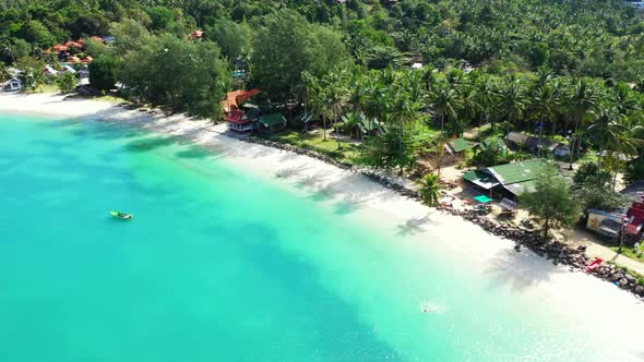 Aerial drone shot tourism of paradise island beach vacation by blue ocean and white sandy background