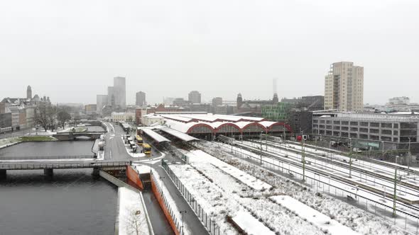 Drone flying towards Malmö Central Station in snow. Turning torso, Clarion Hotel in background