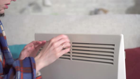 Close Up Young Woman Freezes in the Living Room and Heats Herself Next To an Electric Heater