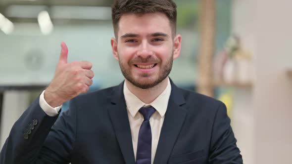 Positive Young Businessman Doing Thumbs Up