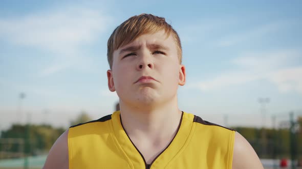 The face of a young nerd on a basketball court