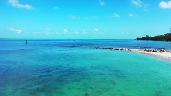 Aerial drone shot seascape of marine lagoon beach journey by shallow ocean with bright sand backgrou
