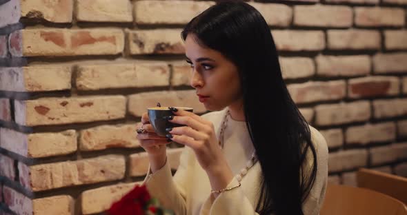 Pretty Woman Drinking Tea in a Cafe