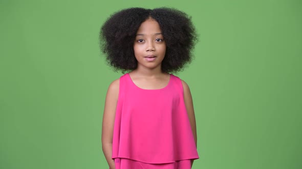 Young Cute African Girl with Afro Hair Against Green Background