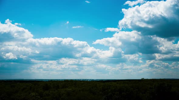 White Fluffy Clouds Slowly Float Through the Blue Daytime Sky Timelapse