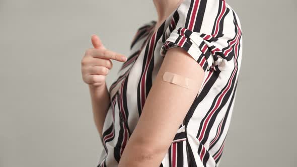 Young Woman Showing COVID19 Vaccine Bandage Merrily