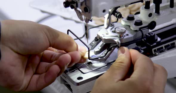 Tailor adding button to electric sewing machine