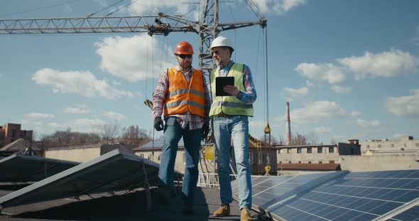 Engineer and Technician Discussing Between Solar Panels