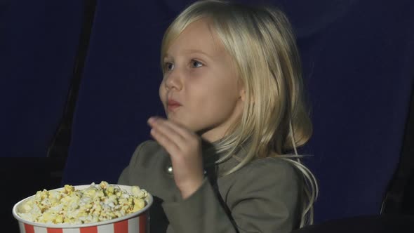 Cropped Shot of an Adorable Little Girl Eating Popcorn While at the Movie Theatre