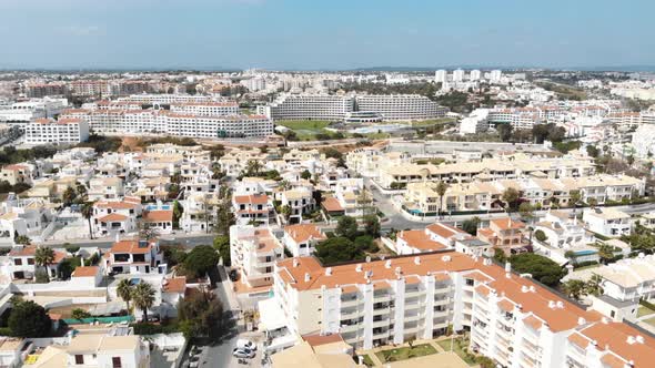 4k drone footage panning the horizon, revealing the popular coastal resort town of Albufeira