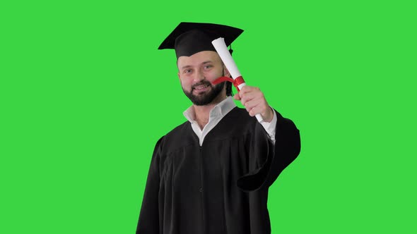 Young Male Smiling Graduate Showing Thumb Up on a Green Screen, Chroma Key