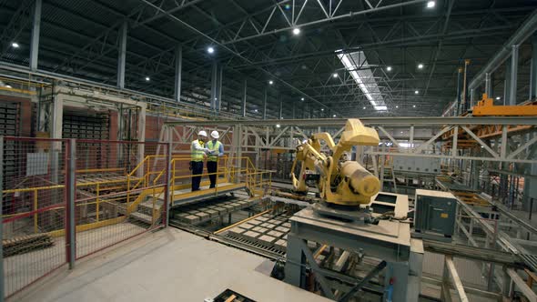 Two Engineers Working at Modern Factory Floor
