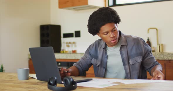 African american man working from home and using laptop