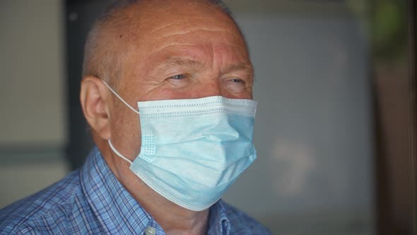 Man in Face Mask Behind Window