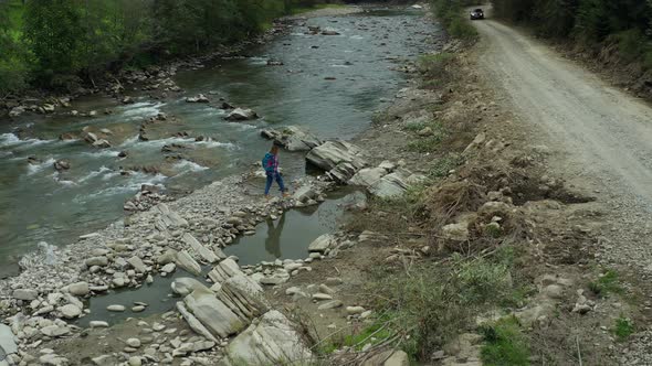 Woman Walking Rocky River Shore Exploring Among Green Spruce Forest Enjoying