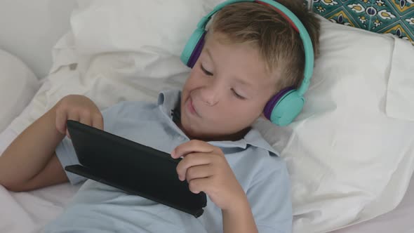 Kid relaxing with tablet PC at home