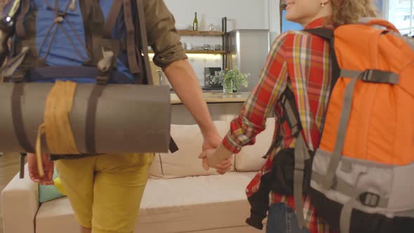 Cheerful Couple of Backpack Travelers Moving in Rented Accommodations