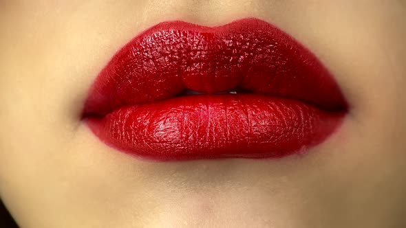 Closeup of Female Lips Covered with Red Gloss
