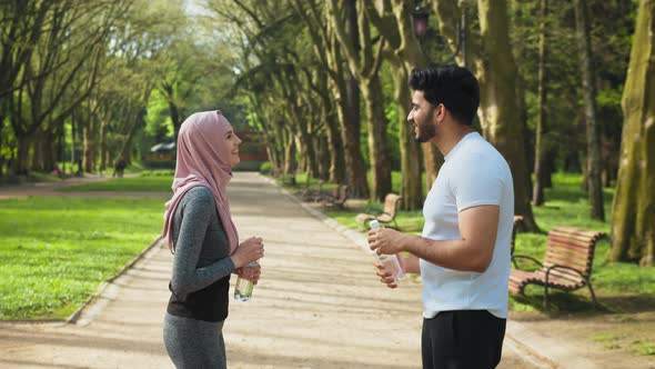 Happy Muslim Man and Woman in Hijab Giving High Five to Each Other Smiling and