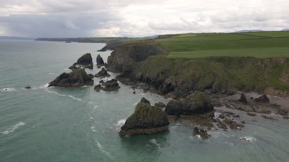 Drone shot of large rocks at an Irish beach on an overcast summers day.