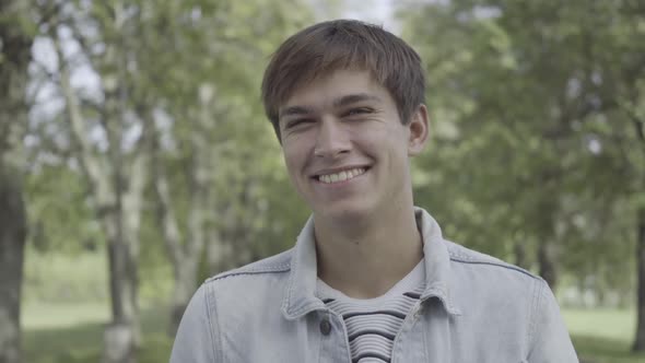 Closeup Portrait of Happy Young Caucasian Man Looking at Camera and Laughing Out Loud