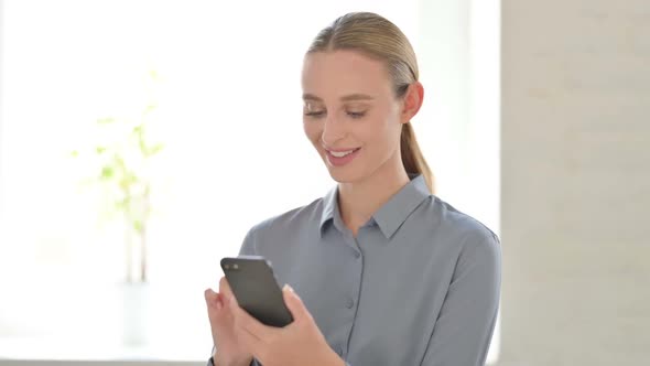 Woman Celebrating Online Success on Smartphone