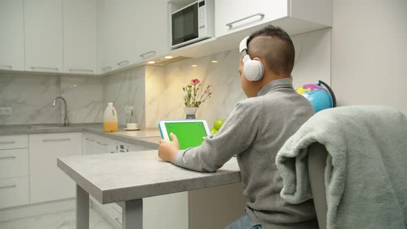 Back View of Child Spending Leisure Time By Using Gadget at Home