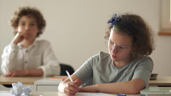 Classmates, a Boy and a Girl Are Sitting at Their Desks During the Lesson. Back To School, New